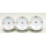 A set of twelve Meissen plates with embossed floral decoration of painted flower sprays in gilt