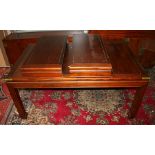 A Chinese hardwood extending dining table with two extra leaves, the rectangular top with brass