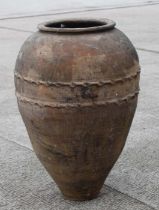 A large terracotta olive jar of tapering cylindrical form with scalloped band decoration, approx