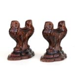 A pair of treacle glazed pottery andirons in the form of stylised owls, 23cms high (2).