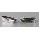 A pair of Chinese white metal shoe form ashtrays, 10cms long (2).Condition ReportThere are no makers