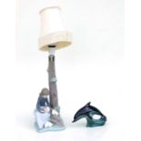 A Nao figural table lamp in the form of a girl at the base of a tree playing with rabbits, 30cms