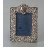 An Edwardian embossed silver photo frame with easel back, Birmingham 1904, overall 17 by 23cms.