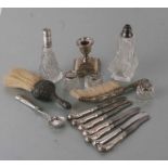 A quantity of silver items to include a dwarf candlestick, crumb brushers, silver handled cutlery