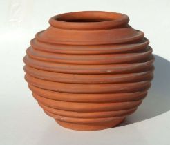A terracotta planter of ribbed form, 33cms high.
