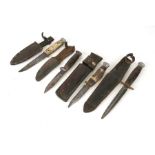 A WWII style fighting knife in leather scabbard; together with three sheath knives with leather