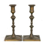 A pair of Georgian brass candlesticks on square bases, 23cms high (2).Condition ReportGeneral wear