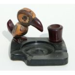 An Art Deco cherry amber Bakelite and nut stylised bird ashtray and match holder, 8cms high.