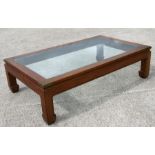 A Chinese hardwood kang or low table with inset glass top and brass corners, 90 by 151cms.