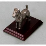 A silver cast model of a fox terrier mounted on a wooden plinth. terrier height 7cm high