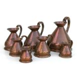 A set of seven graduated copper harvest jugs, the largest 24cms high (7).