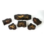 A group of six Chinese lacquered boxes decorated with gilded landscape scenes on a black ground, the