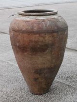 A terracotta olive jar of tapering cylindrical form with sgraffito decoration, approx 56cms high.