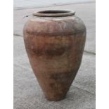 A terracotta olive jar of tapering cylindrical form with sgraffito decoration, approx 56cms high.