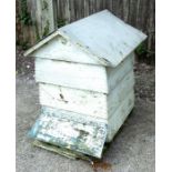 A decorative painted wooden four-section beehive, 85cms wide.