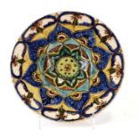 A Della Robbia style pottery shallow dish decorated with stylised flowers, 30cms diameter.