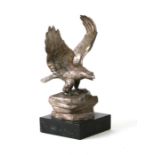 A silver plated model of an eagle with outswept wings mounted on a marble plinth with presentation