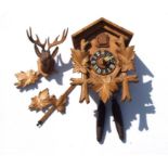A Black Forest style cuckoo clock, the black chapter ring with Roman numerals, the case with
