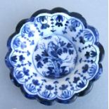 A blue & white delft scalloped edged dish decorated with a bird perched in a tree (restored),