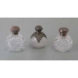 Three large silver topped dressing table scent bottles, the largest 12cms high (3).