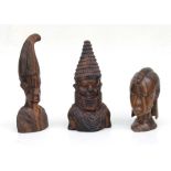 A carved hardwood figure of a Benin lady in tribal dress, 30cms high; together with two similar,