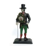 A novelty painted cast iron clock in the form of a clock seller wearing a top hat, 41cms high.