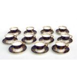 A set of eleven Coalport cabinet tea cups and saucers decorated with gilt swags on a dark blue and