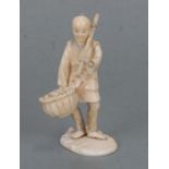 A Japanese ivory okimono in the form of a peasant carrying a basket, two character signature mark to