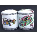 A pair of modern Chinese lidded jars decorated with figures and calligraphy, 24cms high (2).