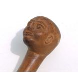 An antique naïve carved Folk Art walking cane with carved head terminal, 97cms long.
