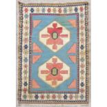 A Turkish rug with two central medallions within a geometric border on a blue ground, 190 by