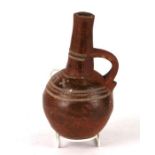 A North African pottery vessel of globular form with single handle and applied decoration, 20cms