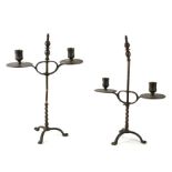 A pair of bronze twin arm rise and fall candlesticks on barleytwist column and tripod base, 39cms