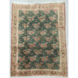 An unusual Persian Sirjan woollen hand knotted rug with repeat rose sprays within a floral border,