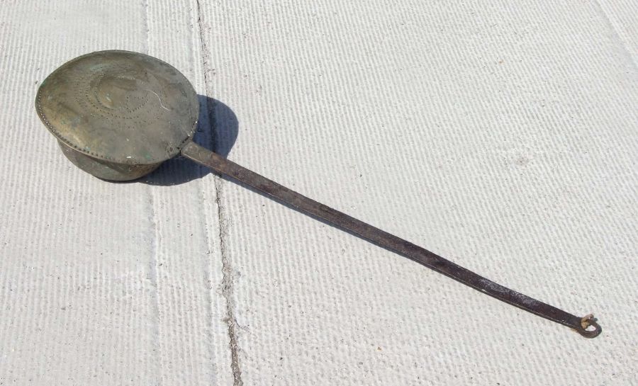 A 17th century pierced brass and steel chestnut roaster, 104cms long.