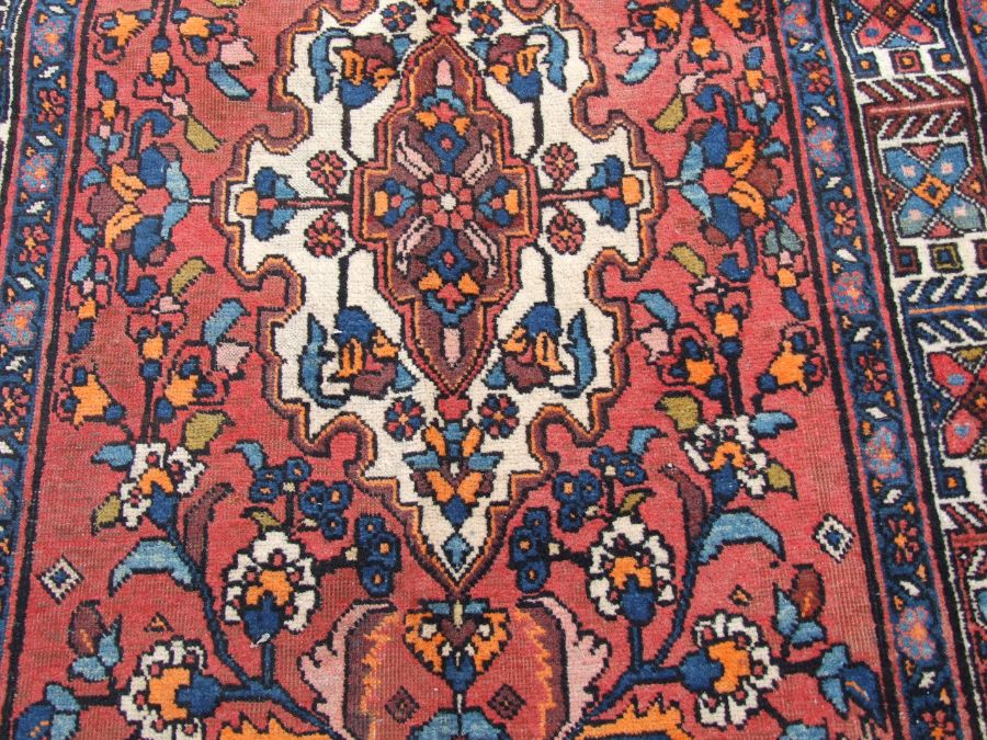 A Persian Azari woollen hand knotted Azari runner with three central guls within geometric floral - Image 4 of 4