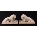 A pair of late 19th century Grand Tour style carved alabaster recumbent male lions, 20cms long.