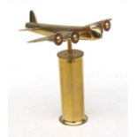 A trench art style model of a Sterling bomber with farthing propellers, mounted on a shell case,