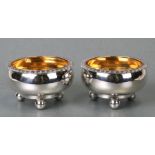 A pair of George III Scottish silver salts of cauldron form with gadrooned rims, on three ball feet,