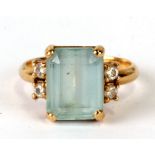 An 18ct gold ring set with a large central stone (possibly aquamarine) flank by diamonds. Approx. UK