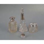 A group of silver topped scent bottles and dressing table jars, the largest 22cms high.