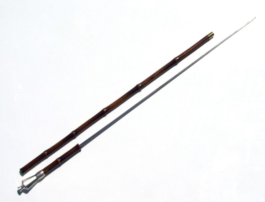 A bamboo sword stick with white metal conical handle and silver collar dated 1911, with triangular