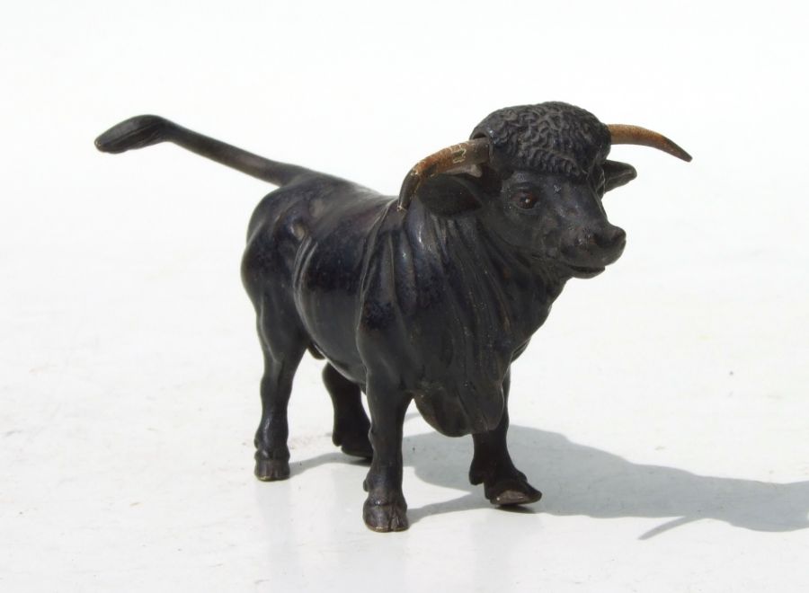 A cold painted bronze figure in the form of a standing bull, 10cms long.