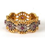 A 14ct gold and garnet flower head eternity ring, approx. UK size 'P', cased.