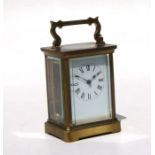 A carriage time piece, the white enamel dial with Roman numerals, in a four pillar brass case,