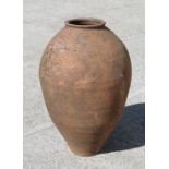 A terracotta olive jar of tapering cylindrical form, 59cm high