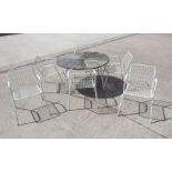 A mid century modern garden table and chairs, having a circular table, 115cm diameter and six wire