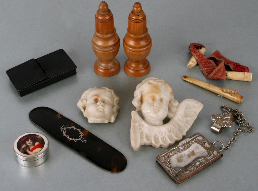 A pair of treen salt and peppers, a silver plated chatelaine notebook, two marble cherub plaques and