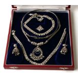 A suite of Indian white metal jewellery to include earrings, necklace and pendant, cased.
