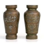 A pair of damascene brass vases of baluster form with scroll decoration, each 15cms high (2).